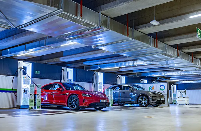 Coches eléctricos en parking con puntos de recarga