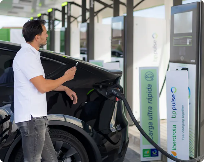 Usuario cargando coche eléctrico en estación